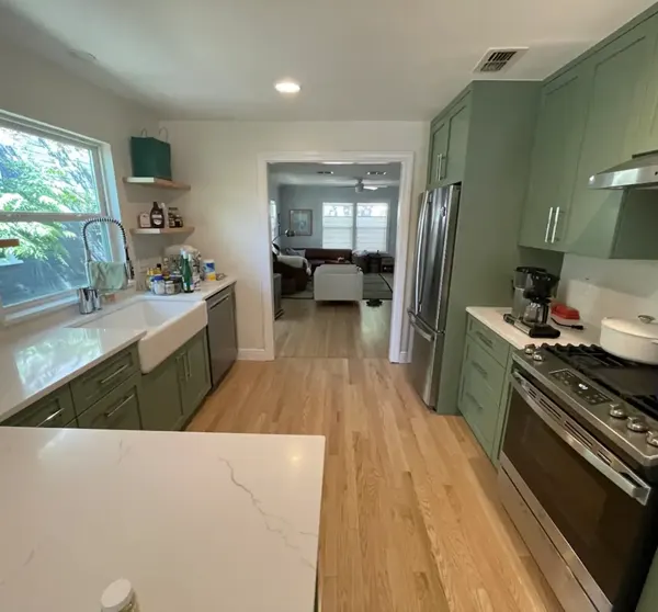 Kitchen remodel with green cabinets and wood floors, Austin area